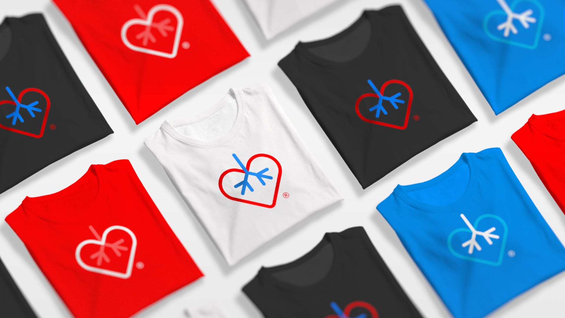 Colorful t-shirts in red, black, blue, and white with heart and snowflake logo designs.